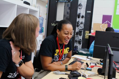 A teacher attending a physical computing sessions laughs as she works through an activity
