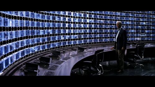 A man standing in front of a wall made of computer screens