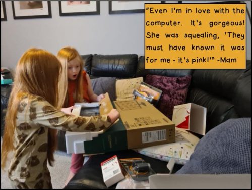 Two young girls unpack a computer display