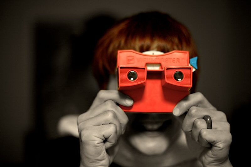 woman holding a view master toy up to her face to look through it