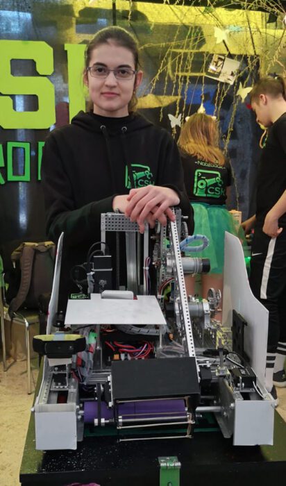A young woman with a robot she has built.